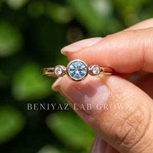 Close-up of the slim 1.30 mm straight polished gold shank on a minimalist three stone gemstone ring.