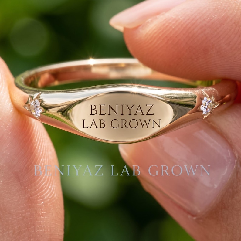 Hand holding a personalized gold wedding band with custom BENIYAZ engraving, polished finish and minimalist ring design against a natural green background