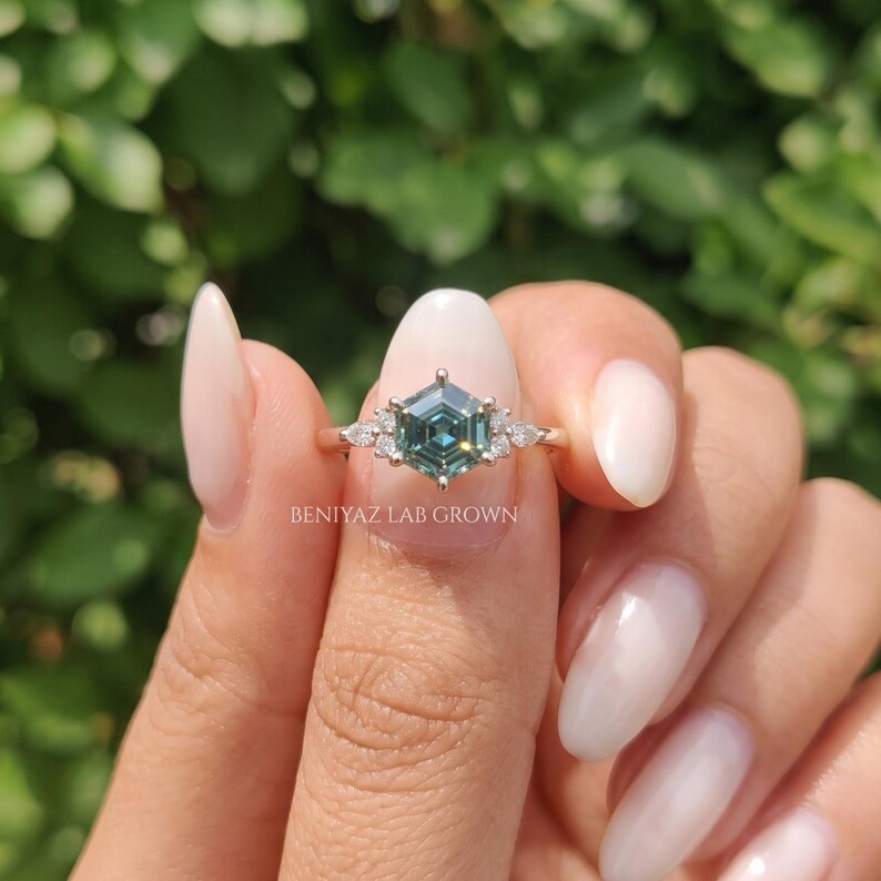 Promise ring for her with cyan blue step cut moissanite, marquise side stones and elegant engagement ring styling.