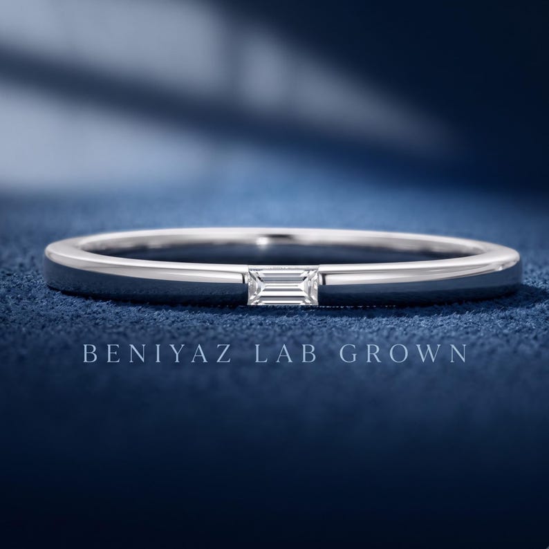 White gold baguette lab grown diamond wedding band with a single horizontal bar set stone on a slim polished band.