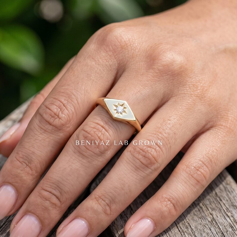 Engraved signet ring style shown on hand with celestial star motif, round diamond center and high polish gold finish.