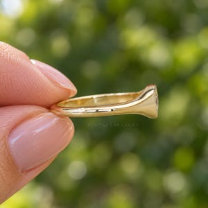 Side profile of diamond signet ring showing low profile star set center, slim tapered band and high polish gold finish