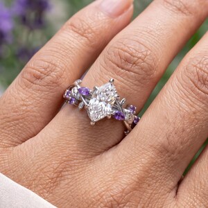 Leaf ring worn on hand with Dutch marquise diamond center, purple Tanzanite side stones and nature inspired openwork design.
