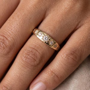 Woman wearing a celestial seven stone diamond band with star set lab grown diamonds and polished gold stacking ring design