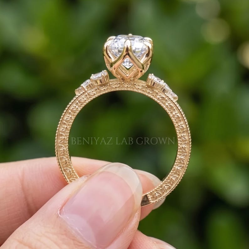 Close up outdoor view of a vintage inspired marquise engagement ring with a large lab grown diamond centre and ornate shoulders.