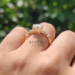 Woman wearing elongated hexagon lab grown diamond engagement ring with geometric side stones and tapered yellow gold band