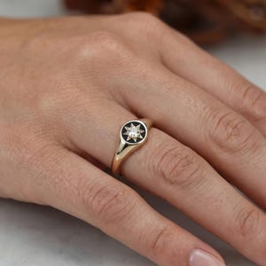 Champagne lab grown diamond signet ring worn on finger showing dainty proportions and star set celestial design