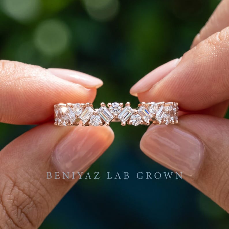 Detailed hand photo of a baguette lab grown diamond wedding band in gold, featuring a sparkling half eternity cluster design and 2.5 mm comfort fit band