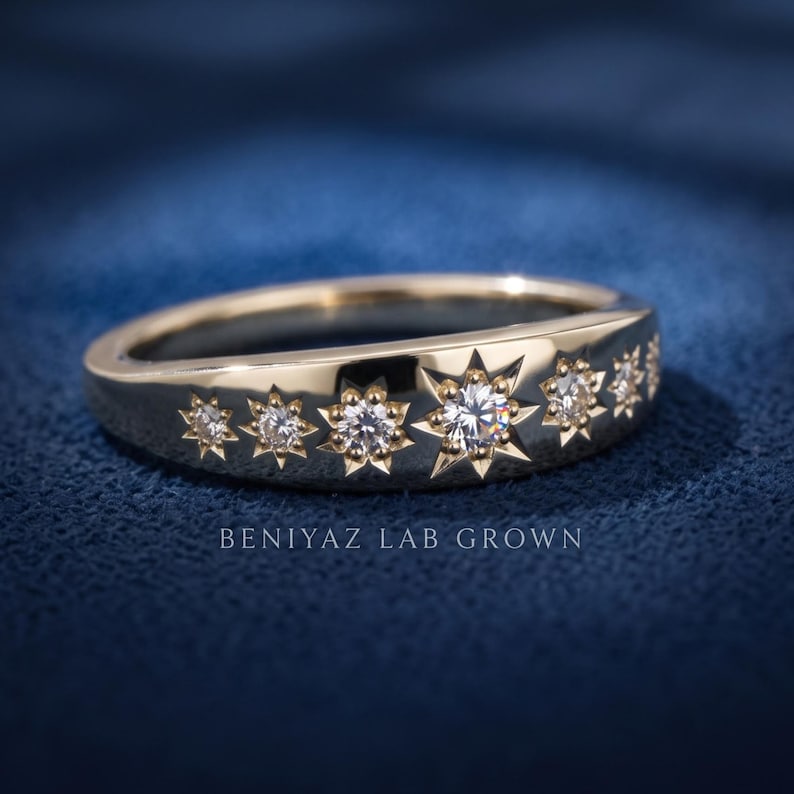 Angled celestial starburst diamond band on blue background with seven graduated round lab grown diamonds and polished finish