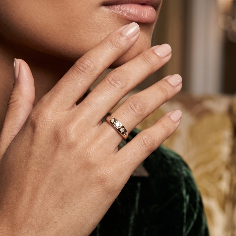 Woman wearing a celestial starburst diamond band with seven lab grown diamonds in a modern gold stacking ring design
