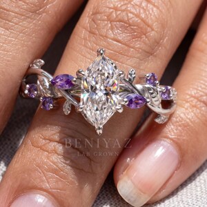Nature inspired engagement ring shown on hand with Dutch marquise center diamond and purple gemstone vine accents.