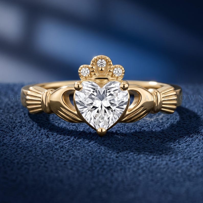 Heart cut lab grown diamond Claddagh ring in yellow gold with sculpted hands, crown detail and heart shaped center stone.