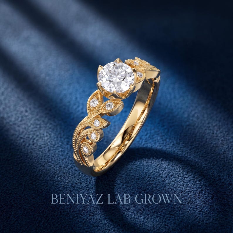 Angled white gold floral engagement ring with a large round lab grown diamond, detailed leaf shaped side settings, milgrain borders and sparkling diamond accents.