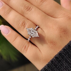 Elongated dutch marquise lab grown diamond engagement ring with alternating marquise and round side stones, front view
