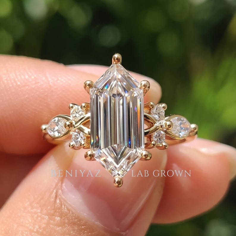 Macro close up of 2 carat elongated hexagon step cut lab grown diamond engagement ring with seven stone side design