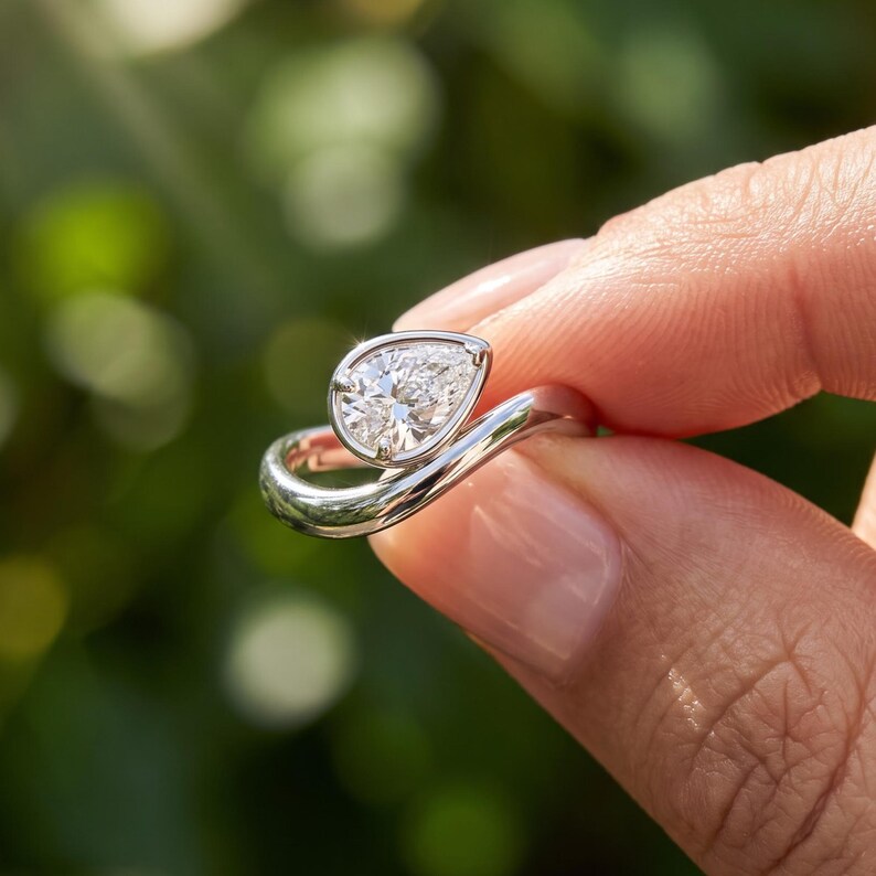 Back shank view of a sculptural pear bypass ring showing the slimmer portion of the band for scale and proportion.