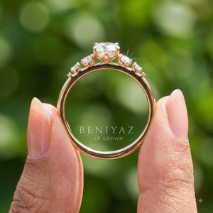 Hand wearing a dainty round lab grown diamond engagement ring in solid gold with a slim 1.9 mm band, delicate minimalist jewelry for everyday wear