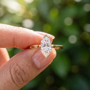Three quarter view of Dutch marquise lab grown diamond solitaire engagement ring showing the pointed center stone and polished band.