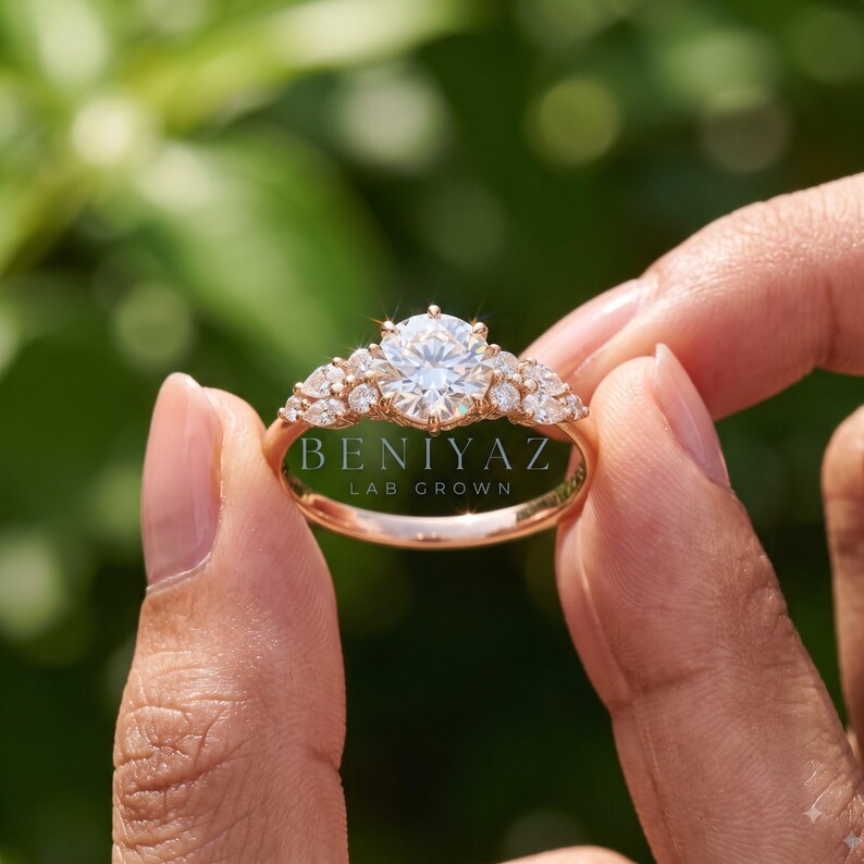 Hand holding a delicate round lab grown diamond ring by the band, highlighting the slim solid gold setting and fine minimalist engagement ring design