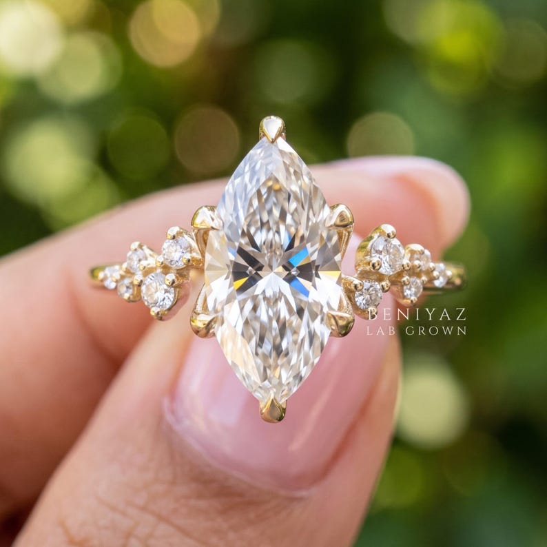 Macro view of vintage engagement ring with marquise lab grown diamond center, clustered side stones and detailed solid gold setting.