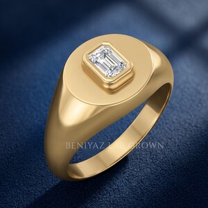Angled studio view of a yellow gold emerald cut lab grown diamond signet ring with broad tapered shoulders.