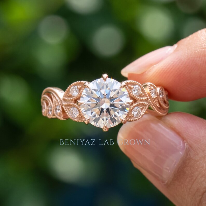 Hand holding a yellow gold lab grown diamond ring with a round center stone and elegant side stone setting, shown in natural light with green background