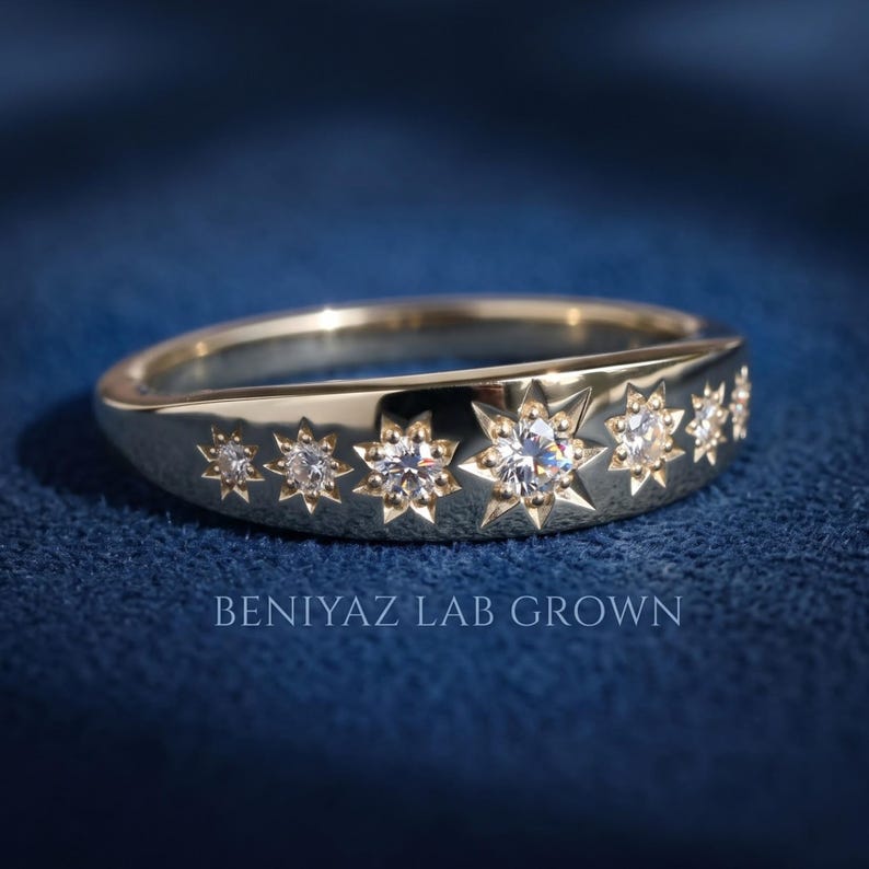 Seven stone celestial lab grown diamond band on blue background showing symmetrical star settings and high polish gold finish