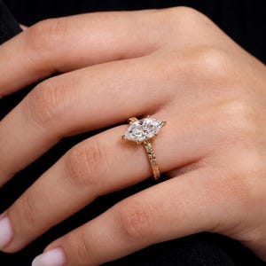 Marquise lab grown diamond engagement ring worn on hand, showing the elongated center stone and true scale.