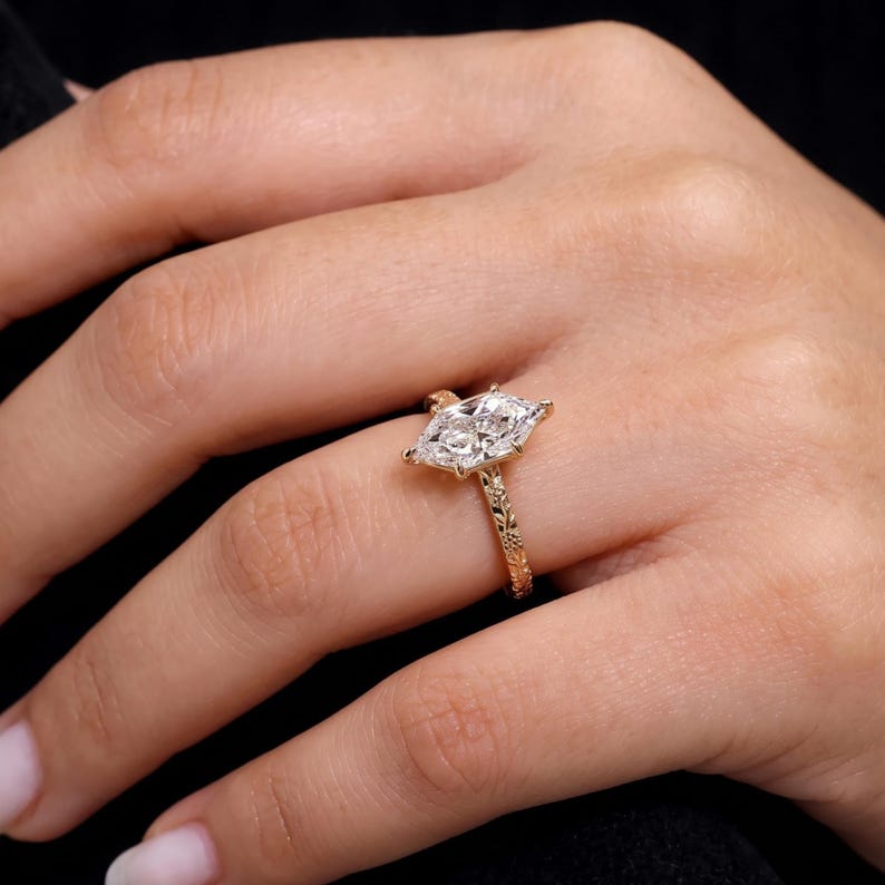 Marquise lab grown diamond engagement ring worn on hand, showing the elongated center stone and true scale.