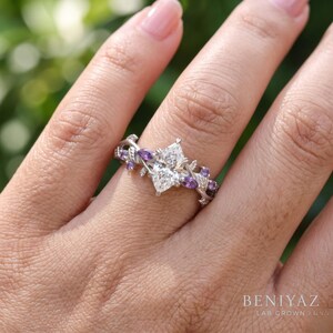 Whimsical engagement ring worn on hand featuring Dutch marquise lab grown diamond and purple Tanzanite botanical details.