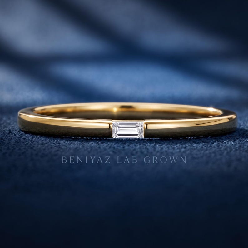 Yellow gold baguette lab grown diamond wedding band with an east west bar set stone and simple polished shank.