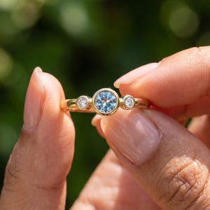 Dainty blue gemstone ring styled with slim stacking bands in solid gold.