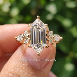 Close up elongated hexagon engagement ring showing 2 carat step cut center diamond with marquise and round lab grown accents