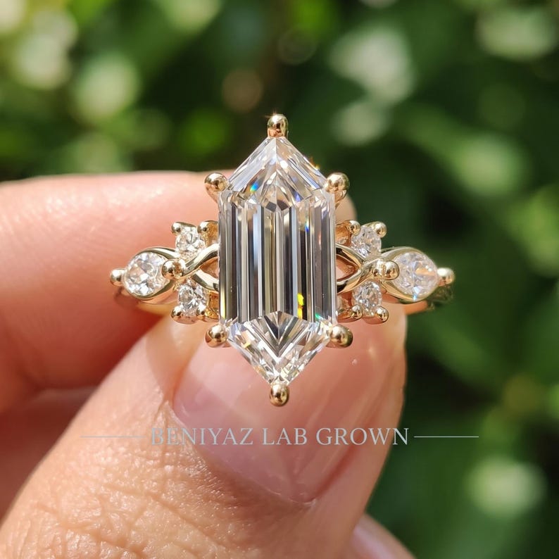 Close up elongated hexagon engagement ring showing 2 carat step cut center diamond with marquise and round lab grown accents