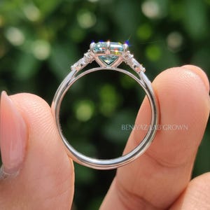 Rear view of moissanite engagement ring showing slim polished shank, prong basket and symmetrical marquise side stones.