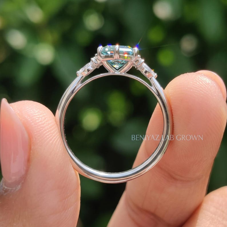 Rear view of moissanite engagement ring showing slim polished shank, prong basket and symmetrical marquise side stones.