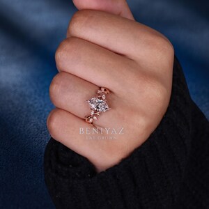 Rose gold marquise diamond engagement ring worn on hand, featuring a nature inspired floral band and sparkling lab grown diamond centre stone.
