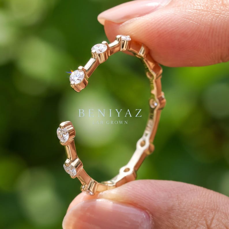 Close up hand view of a yellow gold open gap lab grown diamond ring featuring round diamond tips and a minimalist contemporary fine jewelry design