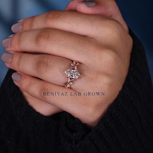 Rose gold marquise lab grown diamond engagement ring worn on hand, showing the elongated centre stone and intricate nature inspired band design.