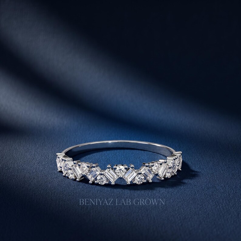 Stackable curved diamond wedding band in white gold with sparkling round and baguette style stones