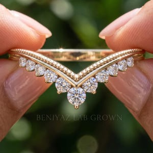 Macro front view of moissanite chevron ring highlighting the V shaped design, larger center stone and graduated side stones.