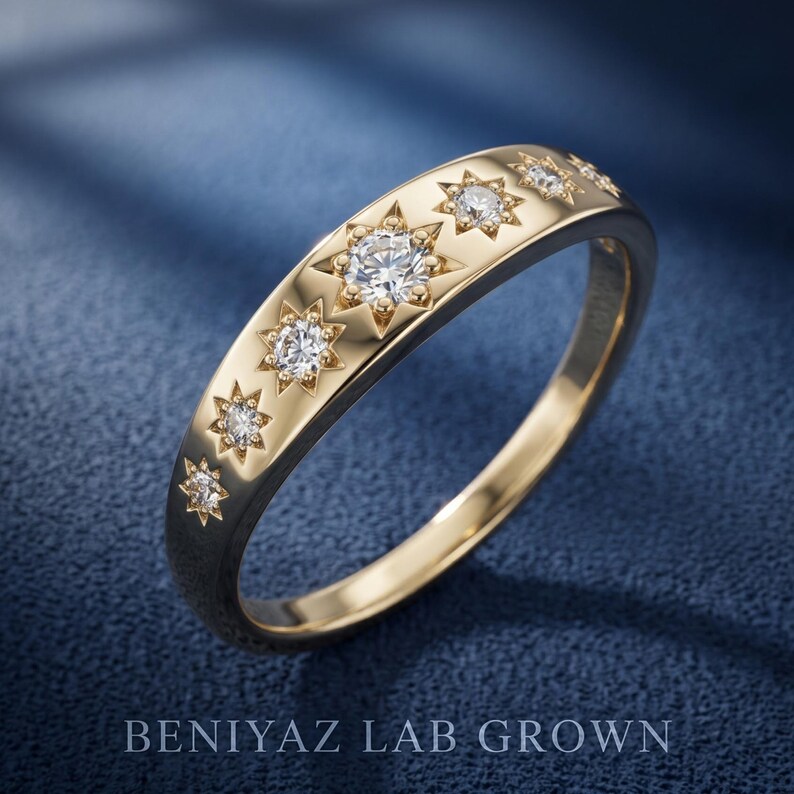 Angled product view of celestial diamond ring on blue background featuring graduated starburst settings and polished gold band