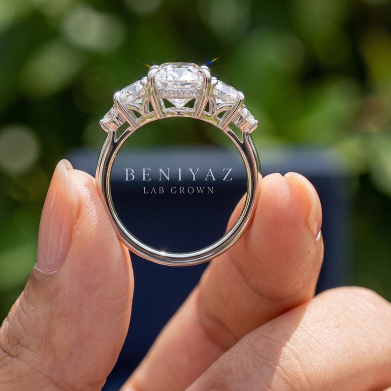 Back view of marquise lab grown diamond engagement ring held by hand showing open setting and polished circular band
