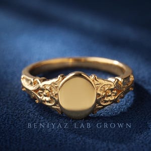 Blank oval signet ring in yellow gold showing the smooth 6 x 8 mm engraving face and detailed vintage floral shoulders.