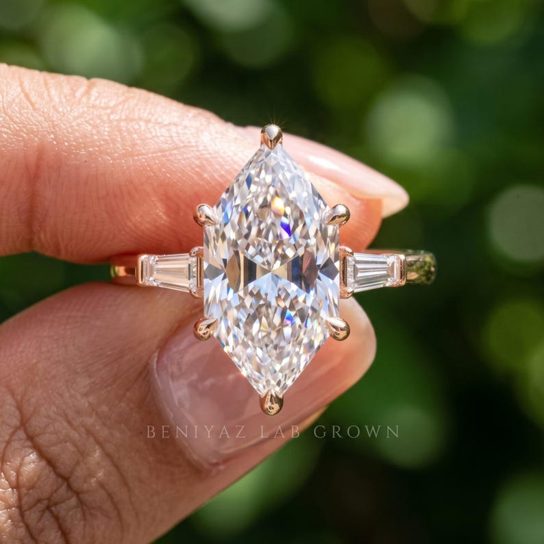 Three quarter hand held view of elongated Dutch marquise lab grown diamond ring with side stones and prong setting