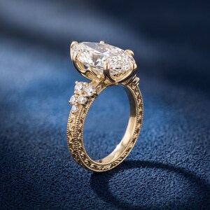 Side view of a 3 carat marquise engagement ring showing the elevated prong basket and vintage inspired diamond accented shank.