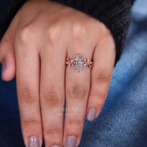 Marquise lab grown diamond vintage engagement ring worn on a woman’s hand, showing the ring scale, floral details and rose gold finish.