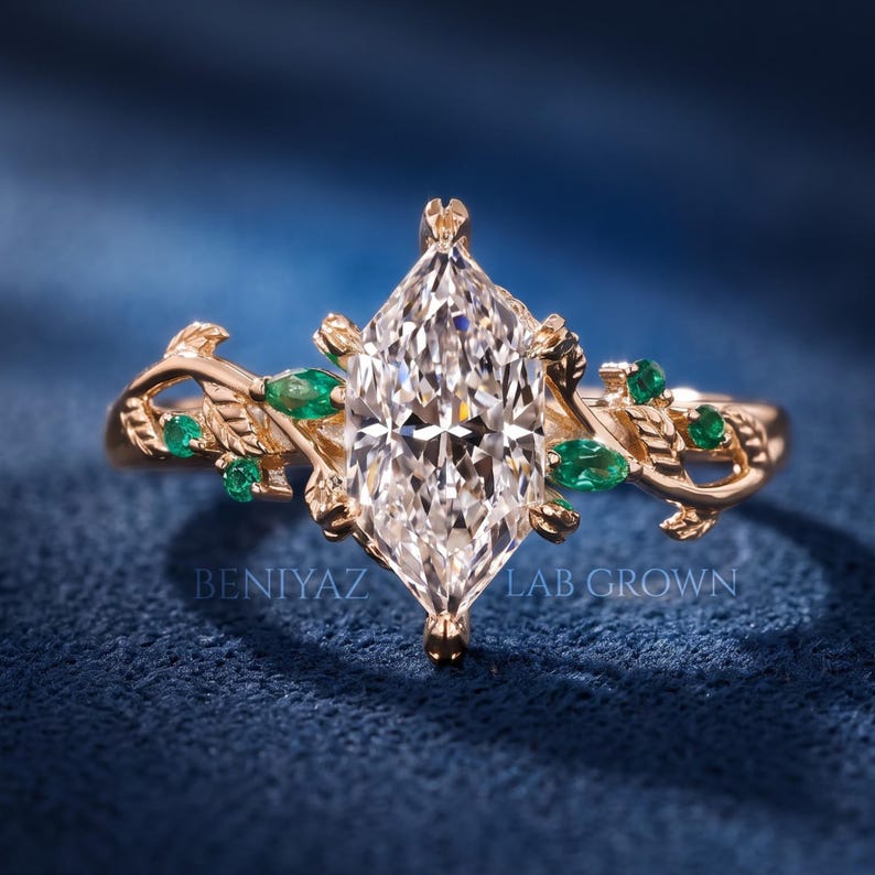 Dutch marquise lab grown diamond engagement ring in rose gold with green accent stones, sculpted leaf prongs and an openwork vine design.