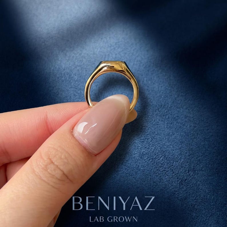 Custom N initial diamond signet ring in yellow gold shown from an angled side view, highlighting the polished gold band, raised signet face and diamond-set letter design.