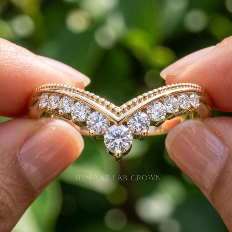 Close front view of moissanite chevron ring with larger center accent and graduated round stones across the V shaped band.